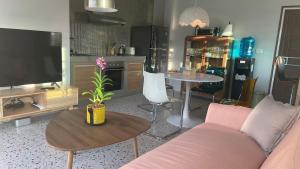 a living room with a couch and a table with a tv at Luxe Sands Pran in Ban Nong Ban Kao