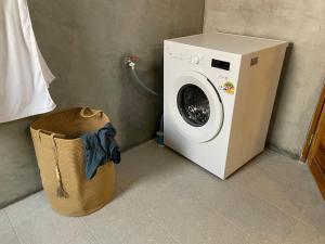 a washing machine sitting next to a trash can at Luxe Sands Pran in Ban Nong Ban Kao