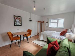 a bedroom with a bed and a table and a couch at The Forest- Mosswood in Cambridge