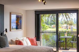 a bedroom with a bed and a sliding glass door at Bermagui Beach Hotel in Bermagui
