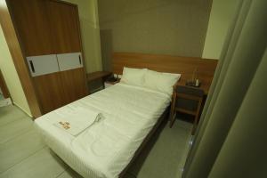 a small bedroom with a bed and a table at Royal Casa Cochin in Cochin