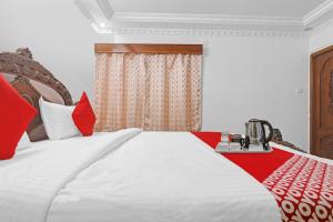a bedroom with a large bed with red and white pillows at Super Hotel O Alpine Glow Crest in Hyderabad +41 photos
