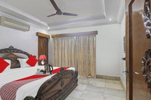 a bedroom with a bed and a ceiling fan at Super Hotel O Alpine Glow Crest in Hyderabad