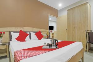a hotel room with a bed with red pillows at Hotel O Padmini Near Lakdikapool Metro Station in Hyderabad +37 photos
