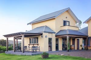 a house with chairs and tables in a yard at Tranquil Vale Vineyard in Luskintyre
