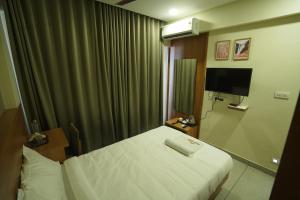 a hotel room with a bed and a television at Royal Casa Cochin in Cochin