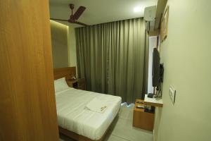 a hotel room with a bed and a television at Royal Casa Cochin in Cochin