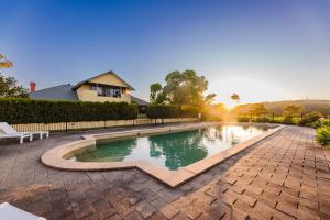 a swimming pool in a yard with a house in the background at Tranquil Vale Vineyard in Luskintyre