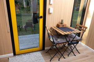 a table and chairs in front of a door at Wilderness Whisper 1770 By Tiny Away in Agnes Water