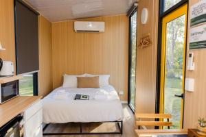 a bedroom with a bed in a tiny house at Wilderness Whisper 1770 By Tiny Away in Agnes Water
