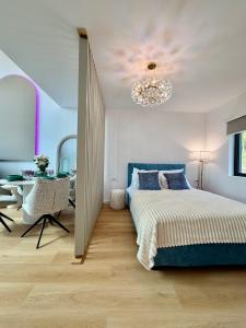 a bedroom with a bed and a chandelier at Panoramic House Baile Felix C2 in Baile Felix +10 photos