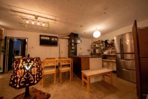 a kitchen with a table and chairs and a refrigerator at SaKuRa B&B in Sakura