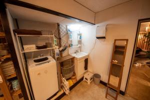 a small kitchen with a sink and a refrigerator at SaKuRa B&B in Sakura