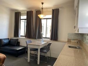 a living room with a table and chairs and a couch at Stonestown Suites in Balulang +11 photos
