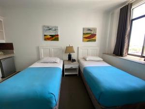 two beds sitting next to each other in a room at Stonestown Suites in Balulang