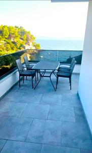 a patio with a table and chairs and the ocean at Apartmani Bradaric Hvar in Gdinj +8 photos