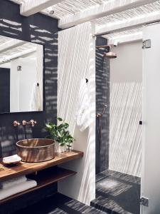 a bathroom with a sink and a mirror at Cavo Tagoo Santorini in Imerovigli
