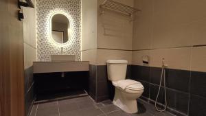 a bathroom with a toilet and a sink and a mirror at sohho Hotel in Cukai +31 photos