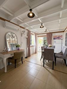 a living room with a desk and a table and chairs at Peace poolvilla sattahip พีซ พลูวิลล่า สัตหีบ in Ban Tao Than