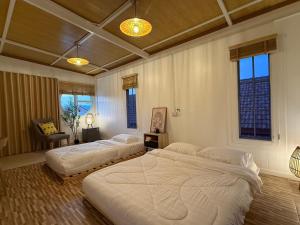 two large beds in a bedroom with windows at Peace poolvilla sattahip พีซ พลูวิลล่า สัตหีบ in Ban Tao Than +38 photos