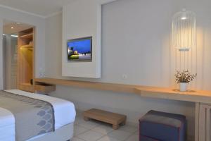 a bedroom with a bed and a tv on the wall at Marilena Sea View Hotel in Pyrgi
