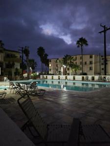 a swimming pool at night with two chairs and a table at Villas Serena Rosarito in Rosarito Beach