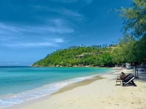 a person sitting in a chair on a beach at Crystal Bungalow DELUXE in Ko Phangan