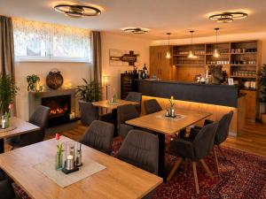 a restaurant with tables and chairs and a fireplace at KOASA HOF Bed and Breakfast in Oberhaag