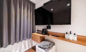 ein Zimmer mit einem Flachbildfernseher an der Wand in der Unterkunft 신촌 어반슬로우 in Seoul