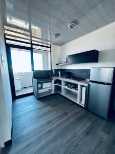 a kitchen with a stainless steel refrigerator and wooden floors at Casa Campamento in La Cueva