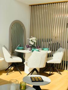a dining room with a table with chairs and flowers at Panoramic House Baile Felix C2 in Baile Felix