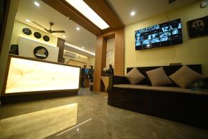 a living room with a couch and a large flat screen tv at Eloras Inn in Siliguri