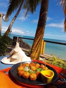 a plate of food on a table near the ocean at Le Lagon Bleu in Antsatrakolo