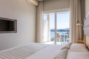 a bedroom with a bed and a large window at Marilena Sea View Hotel in Pyrgi +66 photos