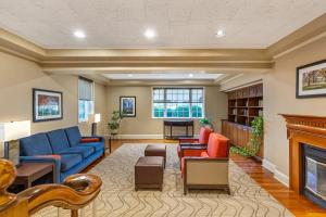 a living room with a blue couch and a fireplace at Comfort Inn Foxboro - Mansfield in Foxborough