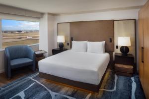 a bedroom with a bed and a chair and a window at Grand Hyatt DFW Airport in Irving +10 photos