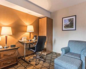 a hotel room with a desk and a chair and a bed at Comfort Inn Drummondville - Highway 20 in Drummondville