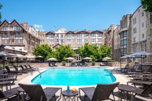 a pool with chairs and tables in front of a building at The Elms Hotel & Spa, a Destination by Hyatt Hotel in Excelsior Springs