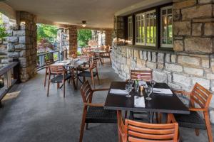 a restaurant with tables and chairs and a stone wall at The Elms Hotel & Spa, a Destination by Hyatt Hotel in Excelsior Springs