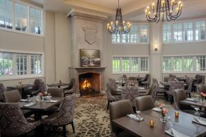 a restaurant with tables and chairs and a fireplace at The Elms Hotel & Spa, a Destination by Hyatt Hotel in Excelsior Springs