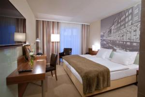 a hotel room with a large bed and a desk at Lindner Hotel Hamburg am Michel, part of JdV by Hyatt in Hamburg +81 photos