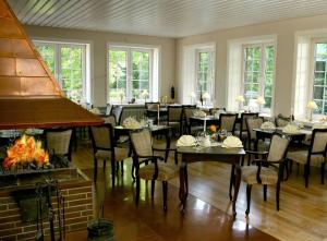 a restaurant with tables and chairs and a fireplace at Bokel-Mühle am See in Bokel