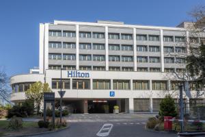 a large white building with a hilton sign on it at Hilton Geneva Hotel and Conference Centre in Geneva