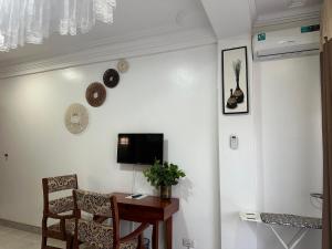 a room with a table and a tv on a wall at Afro-American Motel in Kampala +17 photos