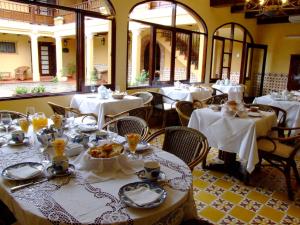 a dining room with tables and chairs with white table settings at Villa Vicuña Cafayate Boutique Hotel in Cafayate