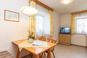 jadalnia ze stołem i telewizorem w obiekcie Appartements Trinker w mieście Zell am See