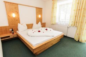 ein Schlafzimmer mit einem großen weißen Bett mit Rosen darauf in der Unterkunft Appartements Trinker in Zell am See