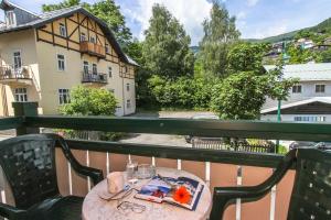 stół na balkonie z widokiem na budynek w obiekcie Appartements Trinker w mieście Zell am See