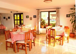 a restaurant with red and white checked tables and chairs at Pensiunea Recanto in Fundata