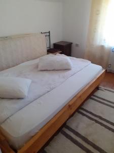 a large bed with two pillows on top of it at Cabana Duma la munte cu ciubar in Dealu Negru